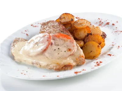 Gratinirani svinjski zrezki z mozzarello in paradižniki ter pečenim krompirjem