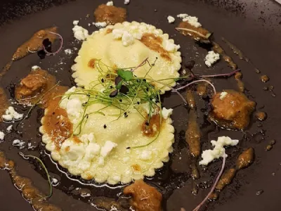 Domači jajčni ravioli s planinsko skuto na jagenjčkovem raguju