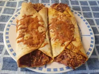 Fotografija recepta: Tortilje z dušenim rdečim zeljem, ribanim sirom in rumeno omako v pečici